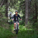 Två personer cyklar i skogen