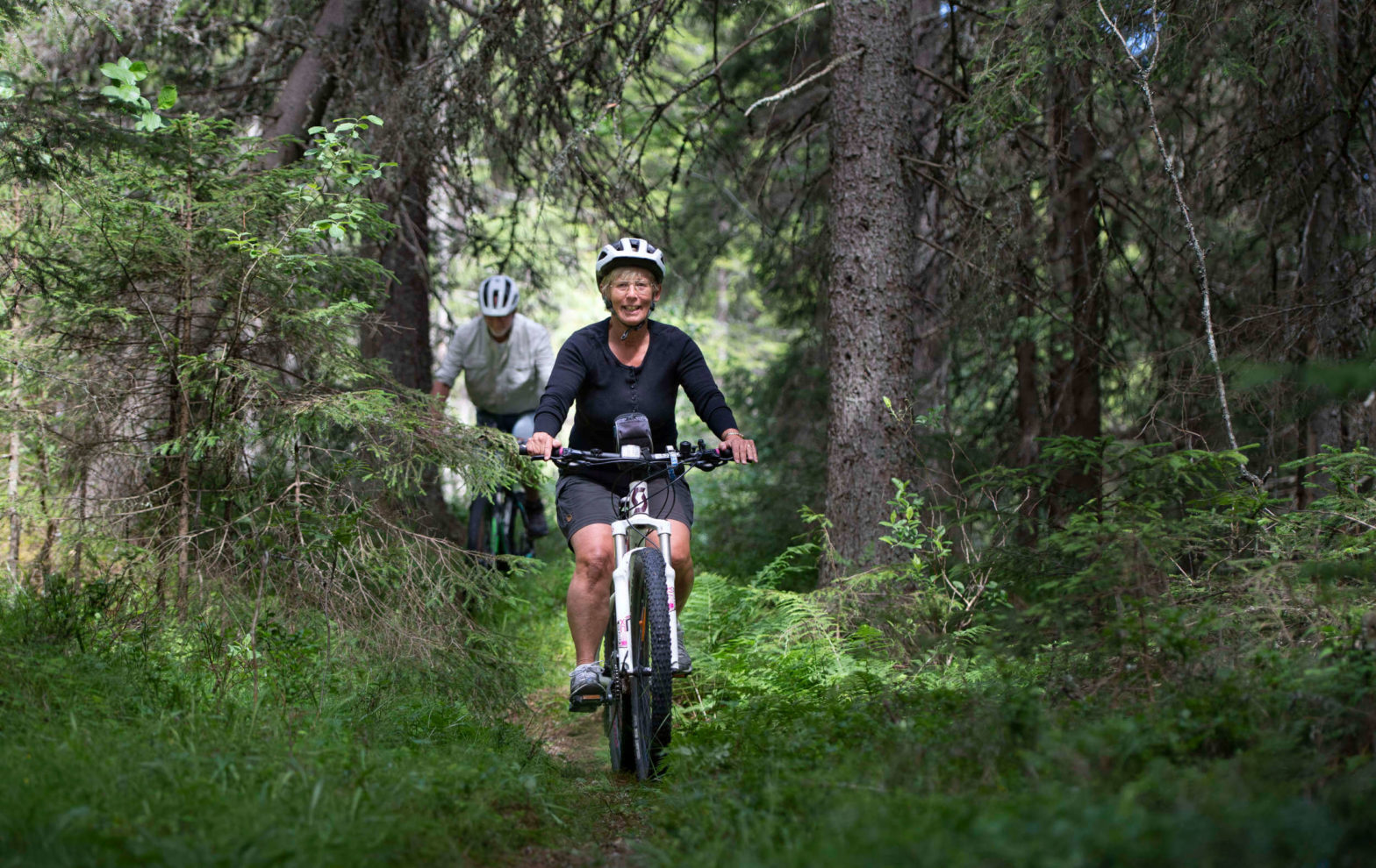 Två personer cyklar i skogen